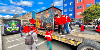 Foto que muestra un grupo de personas empujando un trailer de comidas