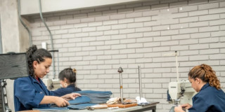 Foto de dos mujeres trabajando en una empresa de textiles.
