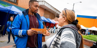 Foto de un gestor social del IPES junto a una vendedora informal en Bogotá.