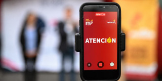 Foto de un celular con logo de canales oficiales de la Alcaldía Mayor de Bogotá.