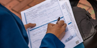 Foto de una persona diligenciando su hoja de vida en una feria de empleo en Bogotá.