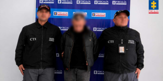 Foto que muestra un capturados y dos personas con uniforme de la Fiscalía