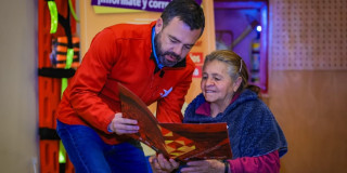 Alcalde Galán entregando el título de propiedad de su vivienda a una señora. 