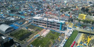 Foto que muestra un edificio en construcción y árboles 