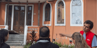 Imagen del director del IDPC con personas al frente de una casa para remodelar