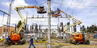 Imagen de dos técnicos de ENEL realizando trabajos en una subestación de energía.