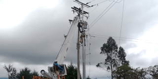 Foto que muestra personas con el uniforme de Enel Colombia trabajando en un poste de luz