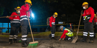 Trabajadores de una obra vial trabajando en la noche.