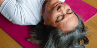 Mujer indígena con los ojos cerrados, acostada sobre el piso boca arriba.