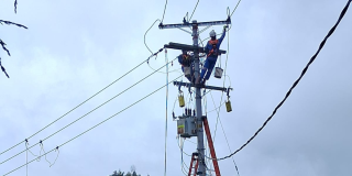 Foto que muestra dos personas con el uniforme de Enel Colombia trabajando en una antena de energía