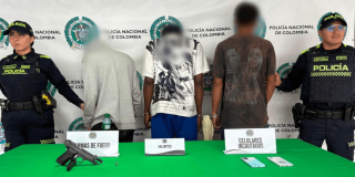 Tres hombres capturados, en medio de dos policías.