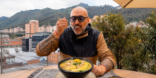 Imagen de un hombre tomando una sopa típica colombiana 'Ajiaco'