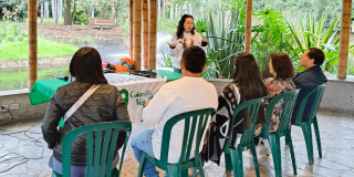 personas sentadas en sillas dentro del Aula Ambiental del Jardín Botánico de Bogotá participan en charla Cada Gota Cuenta a cargo de Colombia Veg.