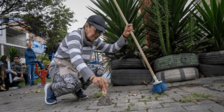 Foto que muestra una mujer arrodillada limpiando el piso 