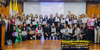 Secretaria de la Mujer, Laura Tami Leal, junto a otras mujeres en un auditorio.