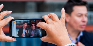 Persona sosteniendo celular en las manos en un medio comunitario de Bogotá.
