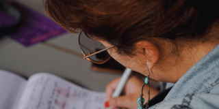 Mujer escribiendo en un papel.