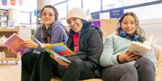 Imagen de tres mujeres sentadas con libros en las Bibliotecas Públicas de Bogotá.