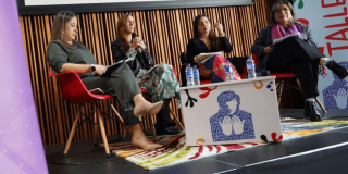 Cuatro mujeres hablando en un conversatorio.