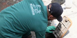 Imagen de un técnico de la Empresa de Acueducto haciendo mantenimiento en un registro o medidor.