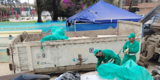Foto que muestra una volqueta y personas agregando residuos 