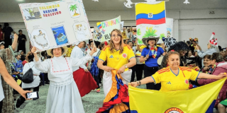 Foto que muestra personas mayores bailando con banderas de Colombia
