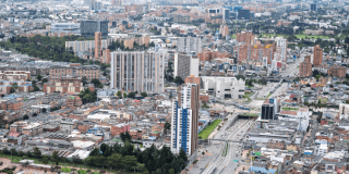 Vista aérea de Bogotá con edificios residenciales y comerciales, corredores viales de alta circulación y amplias zonas urbanas.