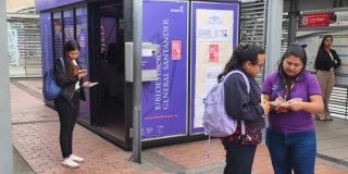 Imagen de personas leyendo libros en una estación de Transmilenio en Bogotá.