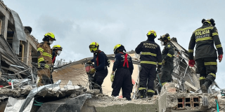 Foto de el Cuerpo Oficial de Bomberos de Bogotá apoyando en los escombros