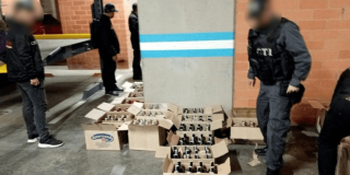 Foto que muestra cajas con licor en el piso y personal de la Fiscalía 