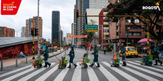 Foto que muestra operarios de aseo cruzando una calle.