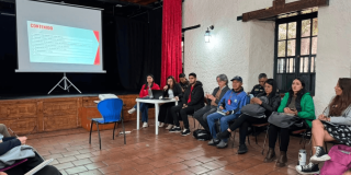 Foto que muestra personas reunidas en un salón hablando 