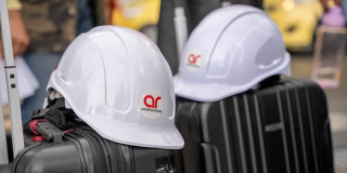 Dos cascos de ingenieros encima de unas maletas de viaje