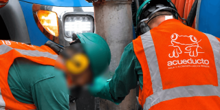 Foto que muestra dos personas con el uniforme del Acueducto de Bogotá