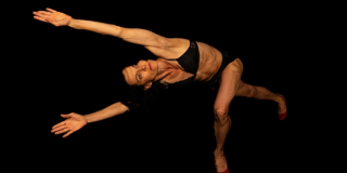 Imagen de una mujer vestida de negro en posición de danza.