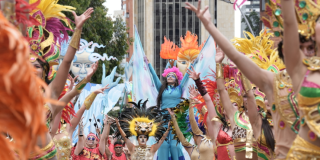 Imagen de varios artistas en las carrozas del Festival de Verano, de fondo se ve el edificio Torre Colpatria.