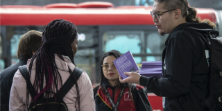 Imagen de varios jóvenes recibiendo ejemplares gratuitas de Libro al Viento en TransMilenio.
