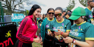 Imagen de una mujer joven que termina el reto y registra su tiempo con facilitadoras del IDRD.