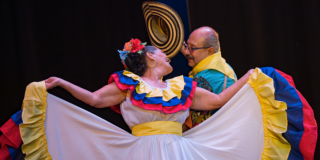 Imagen de un hombre y una mujer mayores bailando cumbia con sus respectivos trajes tipícos.
