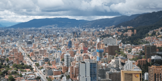 Vista panorámica de Bogotá con edificios residenciales y comerciales de diferentes alturas en primer plano.