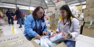 Foto de funcionarios del distrito recibiendo donaciones en Bogotá.