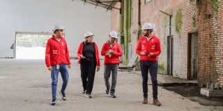 Funcionarios del IDRD con cascos de seguridad recorren una obra en construcción, donde se adelantan trabajos de recuperación de los coliseos menores de la Unidad Deportiva El Salitre.