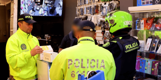 Policías inspeccionando establecimiento de venta de celulares.
