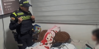 Uniformado de la policía frente a la niña rescatada.