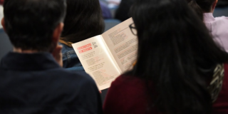 Imagen de personas de espaldas leyendo un folleto de escrituras de Bogotá