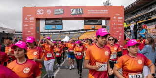 Participantes de la Carrera de la Solidaridad cruzan el punto de salida en el estadio El Campín.