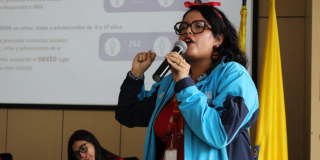 Foto de una mujer hablando en una charla en Bogotá.