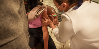 Foto que muestra una enfermera colocando una vacuna en un brazo durante una jornada de salud en Bogotá.