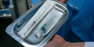 Recipiente metálico con unas jeringas en un puesto de salud en Bogotá.