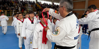 Foto de un niño recibiendo un medalla 
